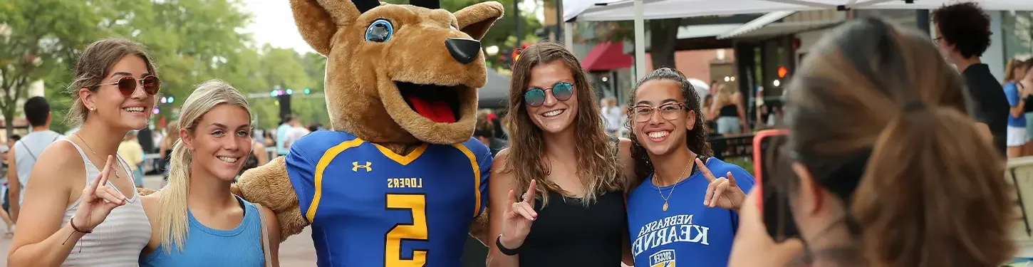 学生 pose with Louie the Loper at the Destination Downtown event